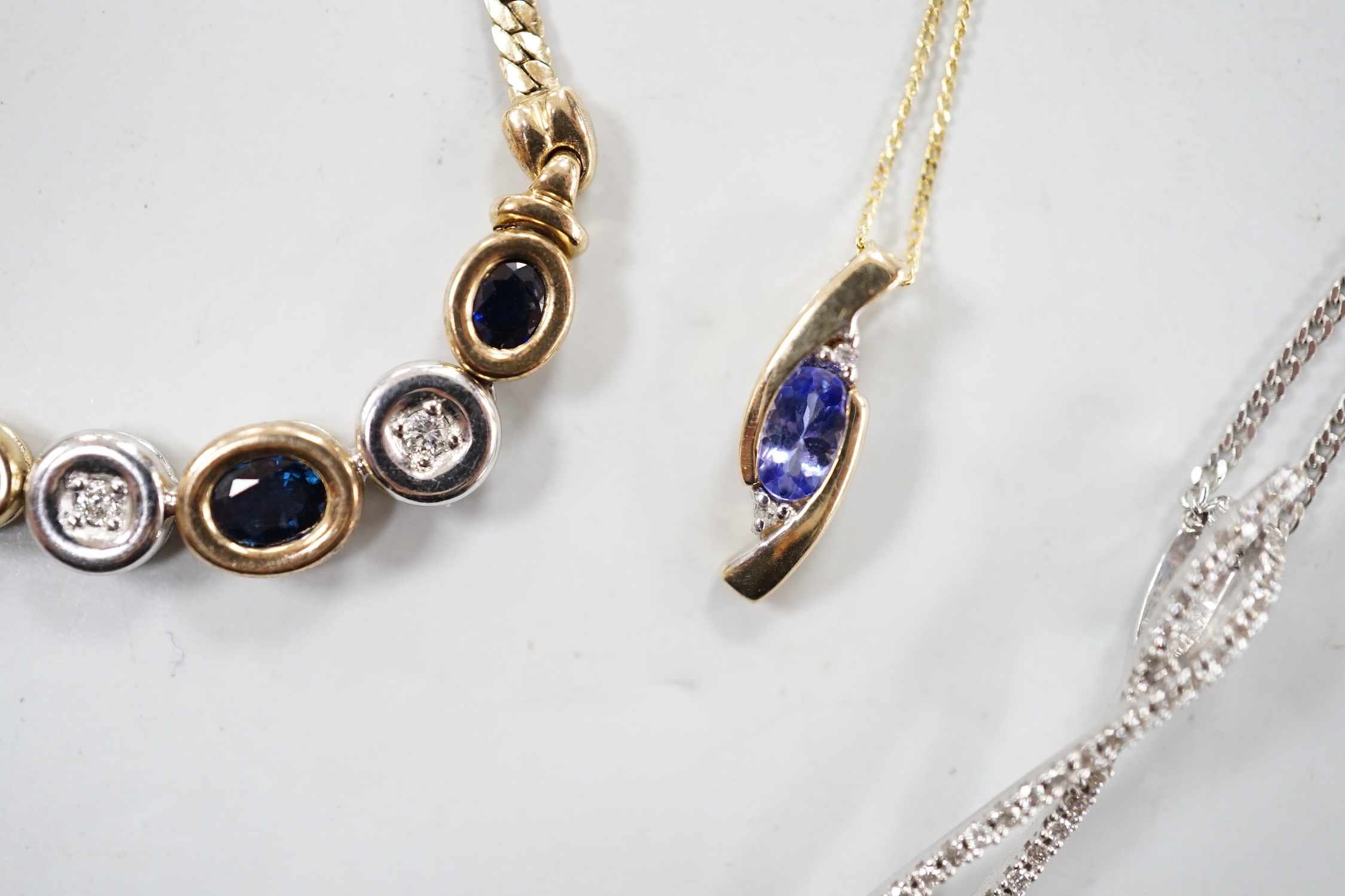 Four assorted modern 375 and gem set pendant necklaces, including white 375 and diamond chip set, 50cm and white 375 and emerald drop set, gross weight 11.3 grams.